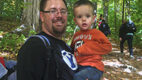 Man in black shirt holding a small boy