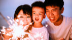 Asian parents and child play with a firework sparkler