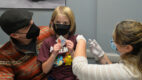 Andrew "Andy" Navarette, age 7, receives the COVID-19 vaccine while surrounded by his parents.