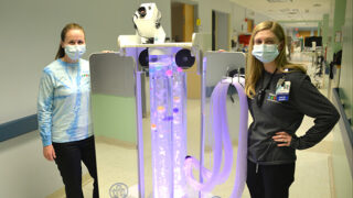 Two nurse standing next to a new mobile unit designed to help soothe and distract pediatric patients with sensory processing disorders, like Autism