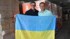 Dr. Vadim Vaisman and Dr. Gennady Bratslavsky holding the Ukrainian flag surrounded by medical supply donations.