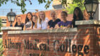 Several young women , members of Albany Medical College’s NextGen Neuroscience Virtual Summer Program, standing outside behind a brick wall at Albany Medical College.