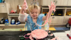 A young girl dressed as a princess makes pink slime