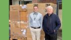 Justin Barnett, CMH Supply Chain Manager, and Reverend Wolodymir Paszko of St. Michael's Church stand in front of donations for the Ukraine