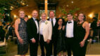 Attendees of the Columbia Memorial Health Annual Ball pose for a photo on the dance floor in formal wear