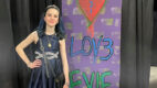 Katelyn Hogan standing next to Calm Lov3 Evie standee