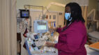 An African American nurse on the apheresis unit, checking a monitor