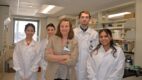 Five research scientists standing in a laboratory