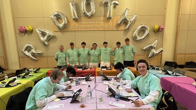 A group of boys standing around the radiothon phone bank