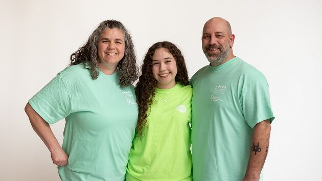 a girl and her parents posing for a picture, in matching radiothon tshirts