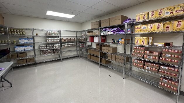 A room with wire shelving, filled with non-perishable food items