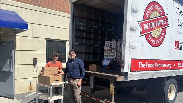 two people unloading boxes from a Food Bank truck