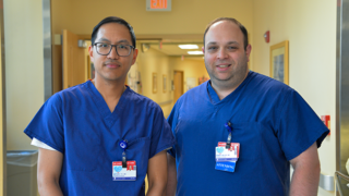 Nathan Tu, MD, otolaryngologist, and Robert Heller, MD, neurosurgeon, standing in hospital hallway.