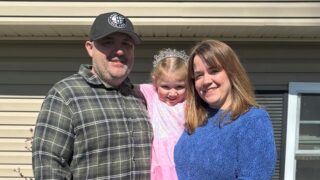 A dad, daughter, and mom posing for a picture