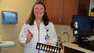 Physician assistant Megan Weitzel in an exam room holding the needle and pigments she uses to create medical tattoos, the final step in breast reconstruction surgery