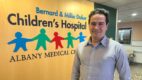 Dr. Ahmed Deniwar standing in front of the children's hospital sign