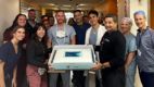 Albany Medical Center Cardiology staff holding a cake with Dr. Neil Yager.