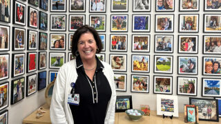 Fran Spreer Albert, System leader, smiles in front of her photo collection.