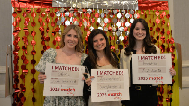 Three medical students hold signs showing where they matched at Match Day 2025